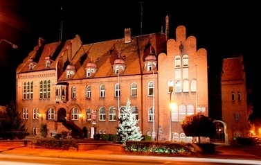 Budynek z czerwonej cegły w porze nocnej, siedziba Starostwa Powiatowego i Gminy czarnk&oacute;w