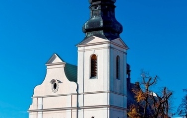 Budynek kościoła stojącego przy ulicy na tle letniego bezchmurnego nieba
