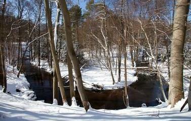Zakręcające koryto rzeki zimą, wok&oacute;ł śnieg