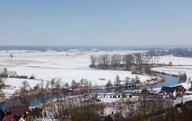 Widok na meandry rzeki, łąki pokryte śniegiem