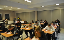 Grupa uczestnik&oacute;w konkursu w trakcie pisania testu