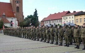 Plener; Plac Wolności w Czarnkowie, na nim żołnierze w mundurach, stojący na baczność.