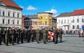 plener; na pierwszym planie osoby składające przysięgę na sztandar; za nimi reszta żołnierzy trzymająca palce do g&oacute;ry, także składająca przysięgę.