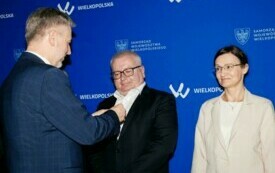 Na zdjęciu widzimy moment wręczania odznak. Marszałek Marek Woźniak przypisana odznakę mężczyźnie, z prawej strony widzimy czekającą na odznaczenie Ewę Dymek - skarbnika starostwa Powiatowego w Czarnkowie. 