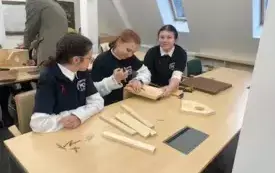 Pomieszczenie, na dużej sali o drewnianych ścianach stoją nauczyciele wyr&oacute;żnieni za przygotowanie uczni&oacute;w do konkursu. Po ich prawej stronie baner z napisem Zesp&oacute;ł Szk&oacute;ł Leśnych Goraj. Za ich plecami choinki. Na suficie okazały żyrandol.