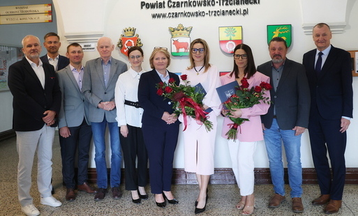 mianowane dyrektorki pozują wraz z Zarządem Powiatu do pamiątkowego zdjęcia na tle herbów gmin w Starostwie powiatowym